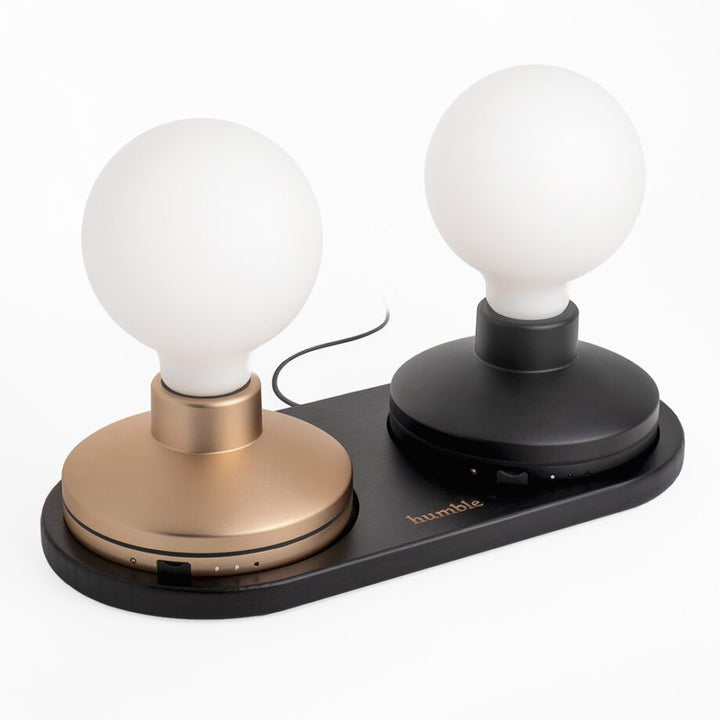 image of humble bee wireless charger in black, charging two humble bee lights