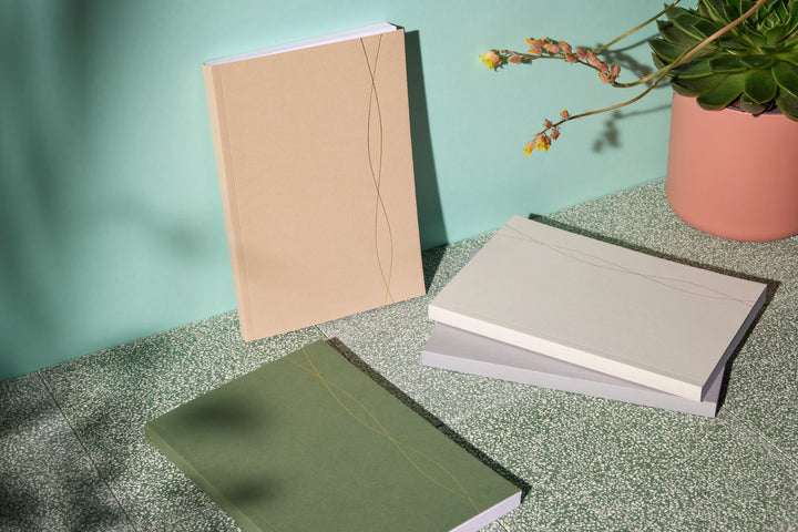 collection of white cream and green notebooks by LSW